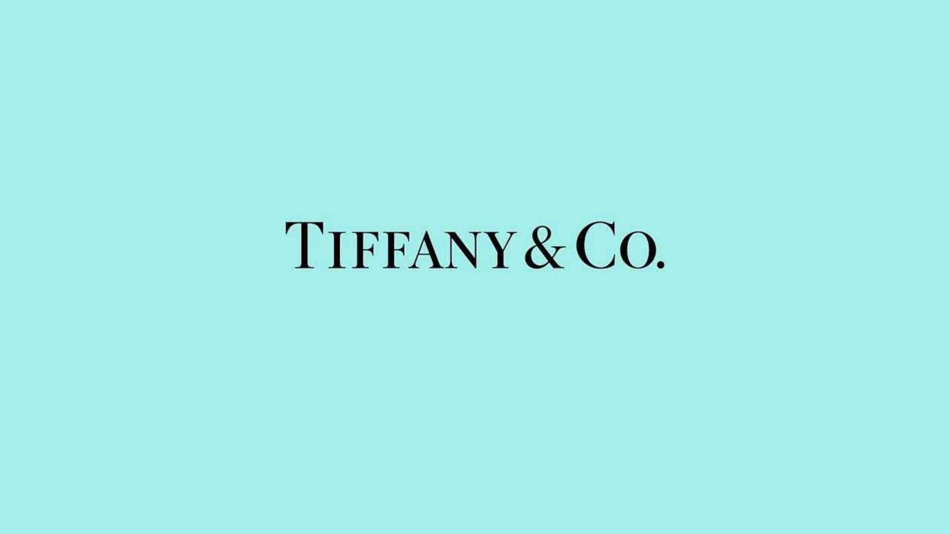 tiffany 桌布 壁紙 — Tiffany & Co. 標誌以優雅的黑色襯線字體居中顯示在純蒂芙尼藍色背景上。