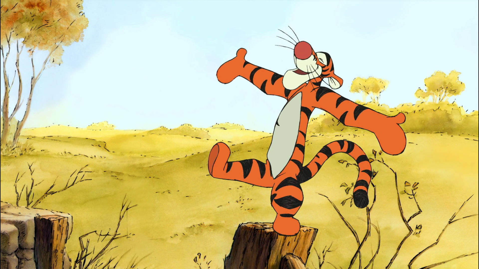 Tigger 桌布 壁紙 — Tigger 在晴朗藍天下的陽光金色田野中，在一個樹樁上開心跳躍，周圍有稀疏的樹木。