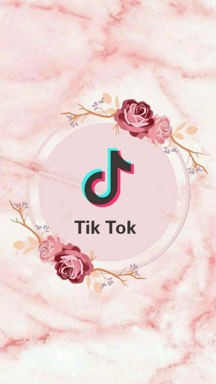 rose aesthetic phone 桌布 壁紙 — TikTok 標誌居中於粉紅色大理石背景上，飾有玫瑰和樹枝的花環。