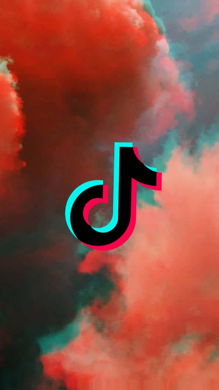 TikTok Logo 桌布 壁紙 — TikTok 標誌漂浮在充滿紅色和藍綠色煙霧的戲劇性天空中，伴隨著漩渦狀的雲層。