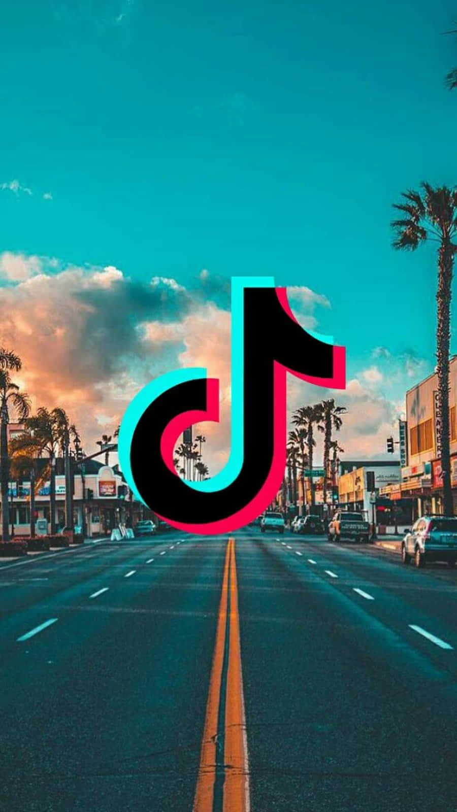 TikTok 動圖 桌布 壁紙 — TikTok 標誌漂浮在日落時分的棕櫚樹街道上，帶有充滿活力的藍綠色和粉紅色調。