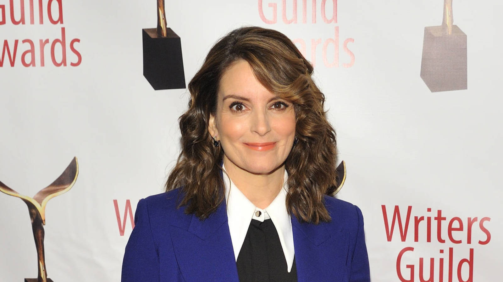 女演員 桌布 壁紙 — Tina Fey 在作家協會獎紅毯活動上，身穿搶眼藍色西裝外套，露出溫暖笑容。
