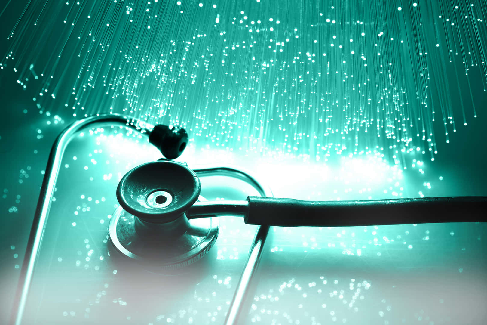 Medicina 桌布 壁紙 — 一個聽診器放在表面上，下方有發光的青綠色光纖線，營造出未來醫療氛圍。