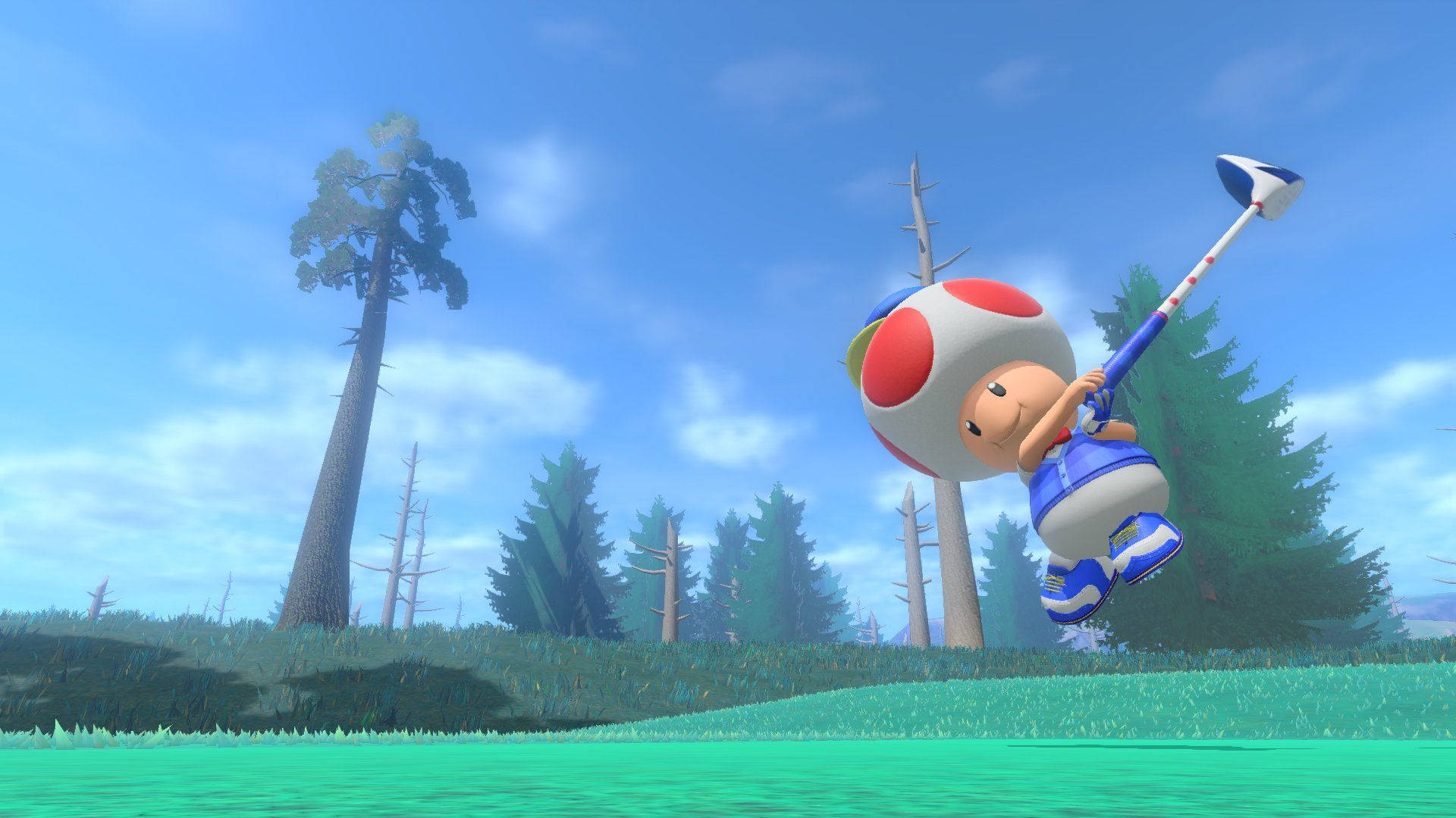 Golfing 桌布 壁紙 — Toad 在充滿活力的綠色球場上，於半空中揮動高爾夫球桿，周圍有高聳的樹木和晴朗的藍天。
