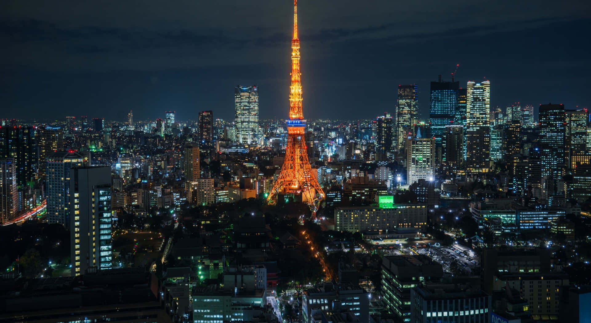 夜晚的東京鐵塔，周圍環繞著閃爍的城市燈光。 — 東京鐵塔 壁紙