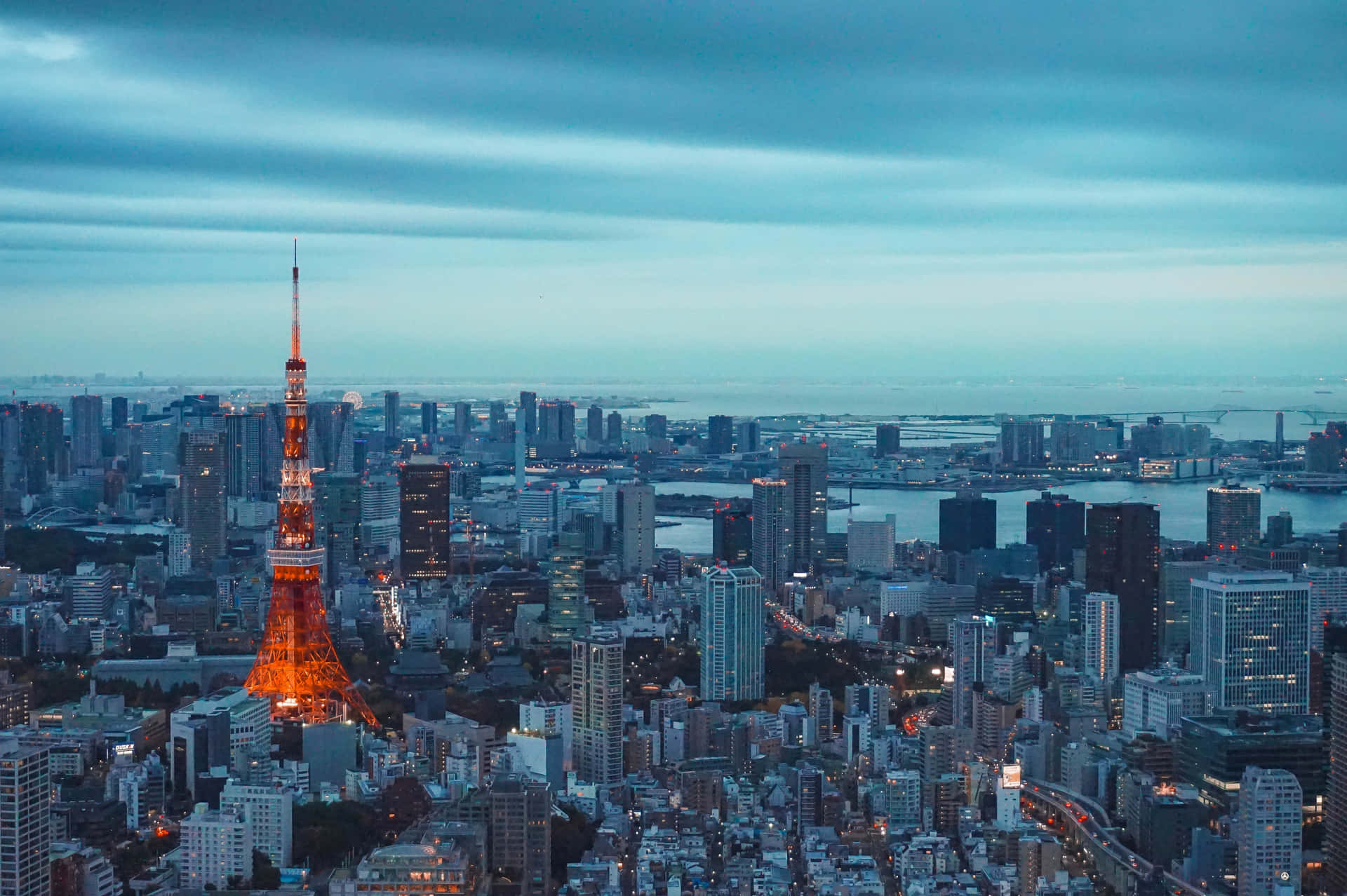 黃昏時分點亮的東京塔，下方城市燈光閃爍。 — 東京鐵塔 壁紙