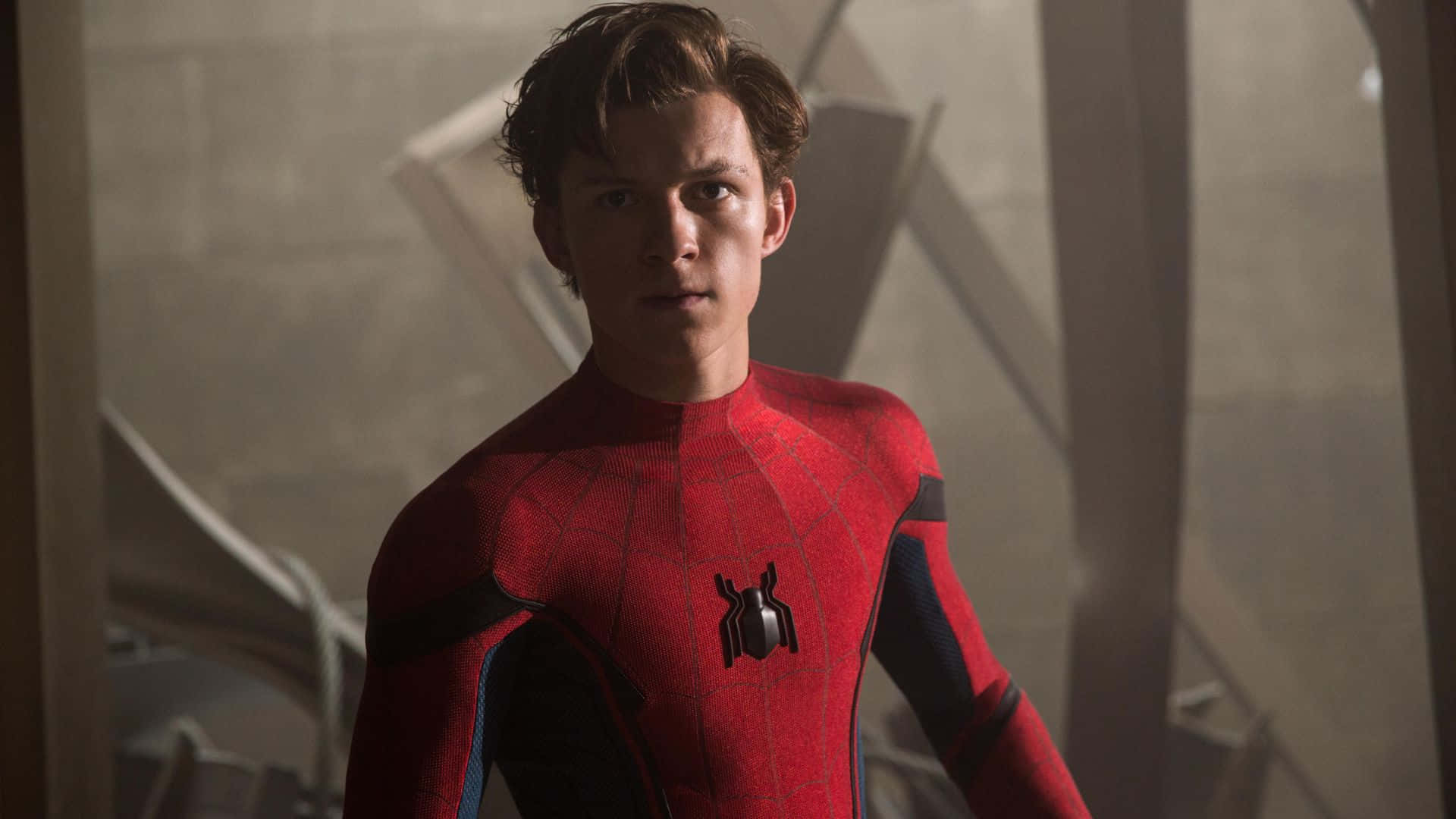 Spider Man Homecoming 桌布 壁紙 — 湯姆·霍蘭德飾演的蜘蛛人穿著紅藍戰衣，站在塵土飛揚的工業環境中，神情專注。