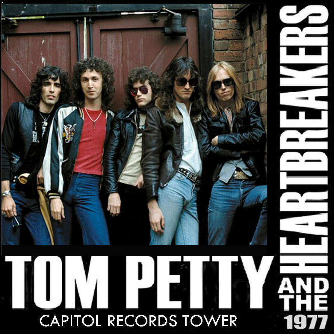 rock n roll 桌布 壁紙 — Tom Petty and the Heartbreakers 自信地穿著皮夾克和太陽眼鏡，以磚牆和紅門為背景擺姿勢。