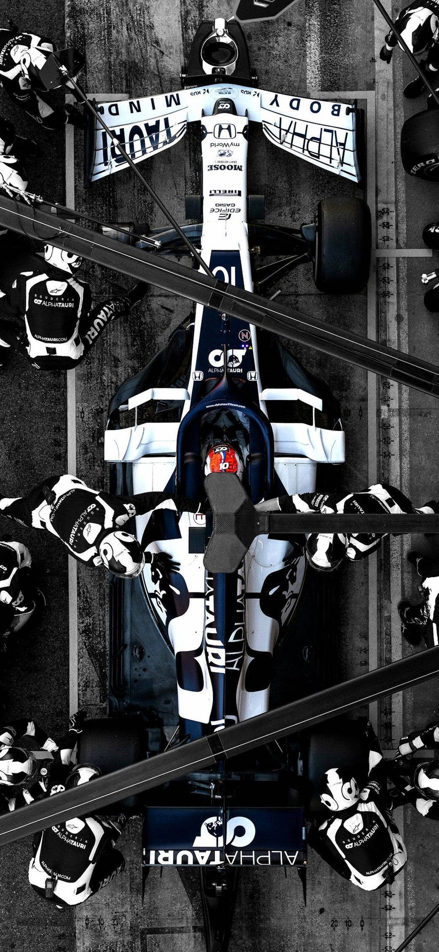 Formula 1 race car with pit crew surrounding it on track. — F1 壁紙