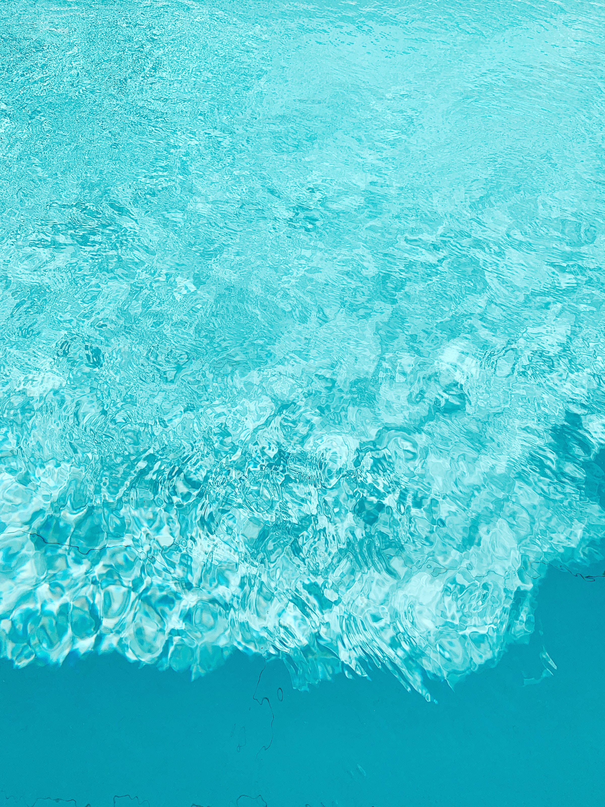 海洋藍 桌布 壁紙 — Top-down view of turquoise pool water with rippling surface and light reflections.