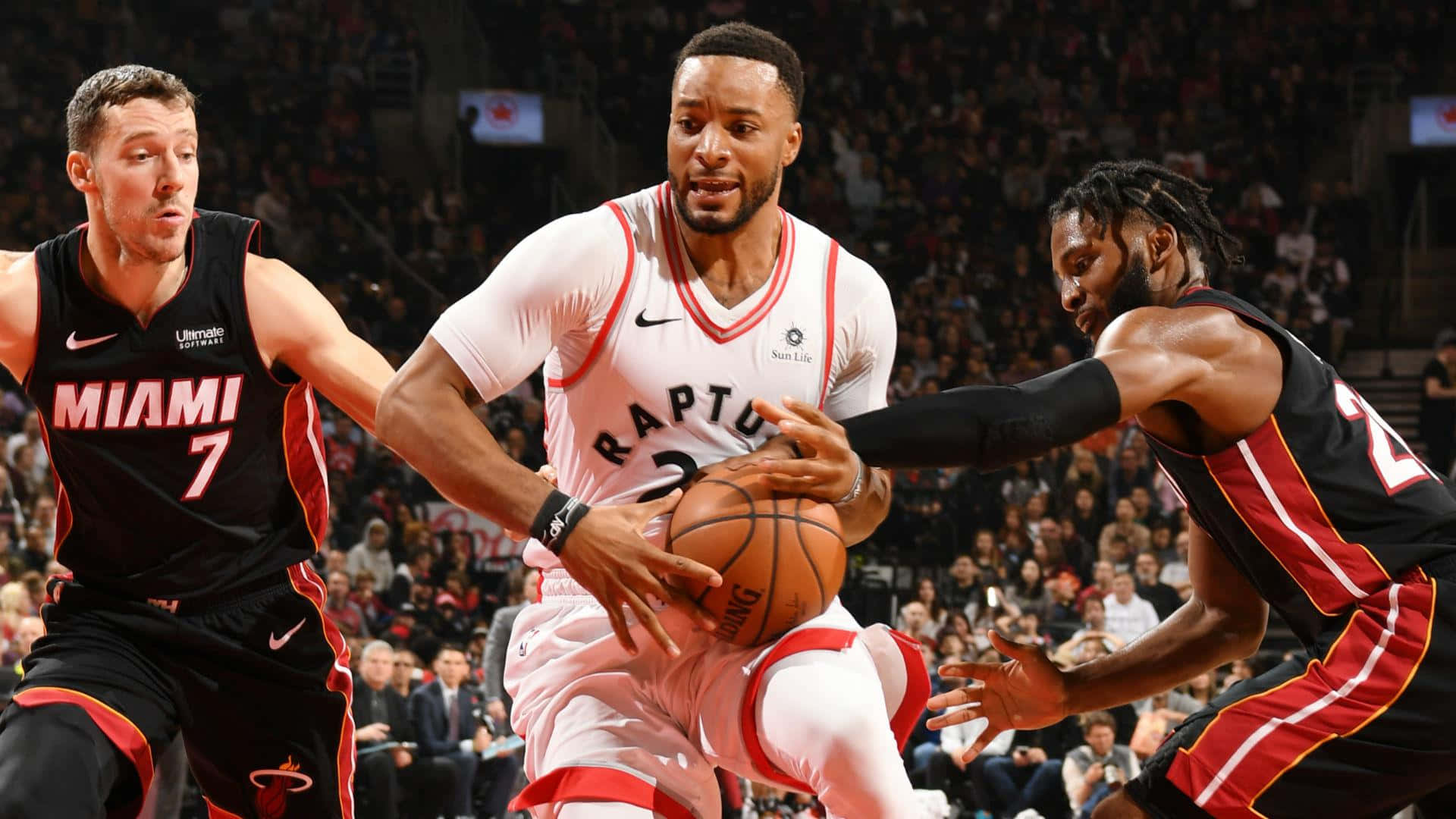 三名籃球運動員在比賽中行動，背景有球迷。 — NBA 壁紙