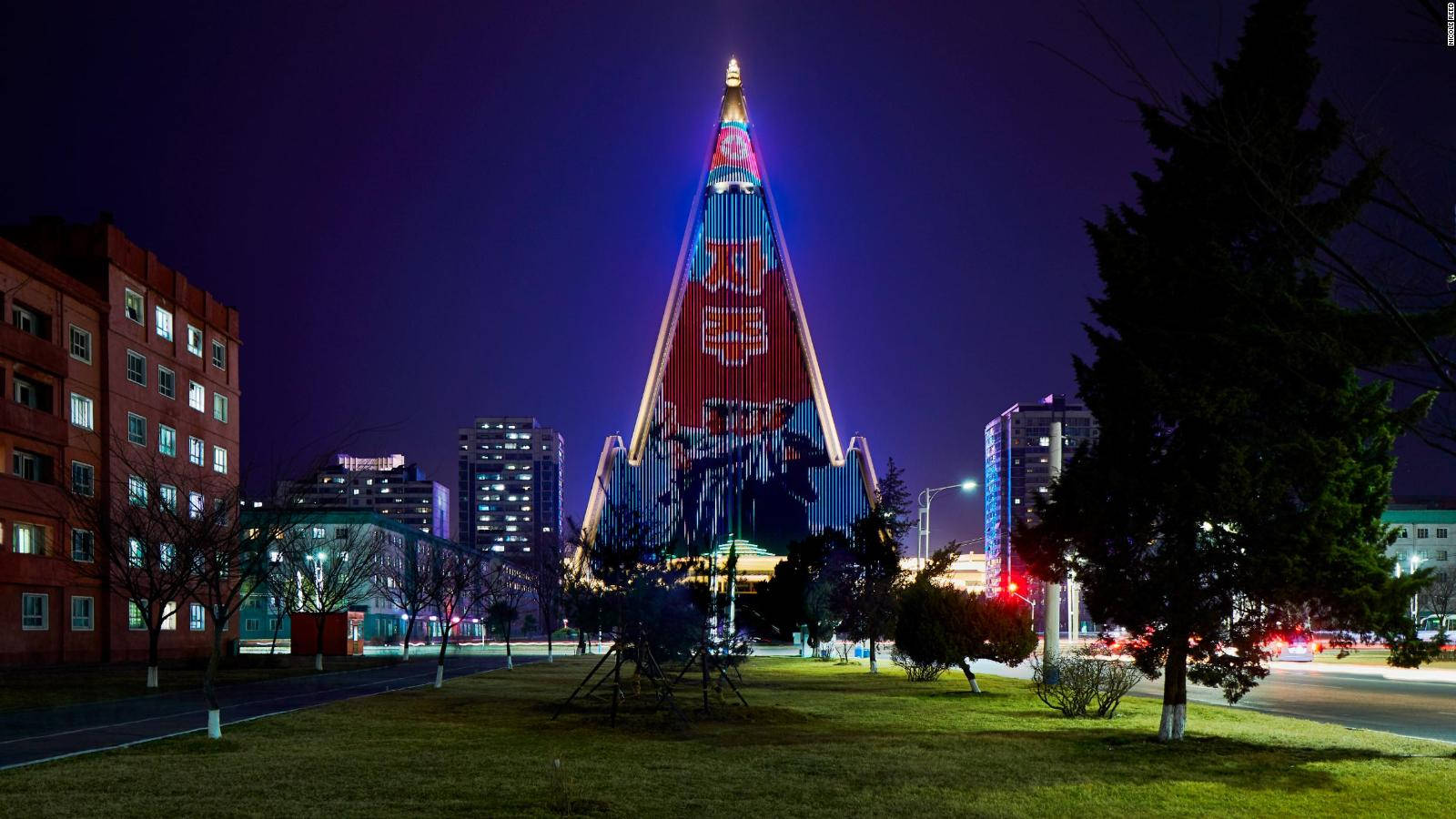 夜間城市環境中，一座明亮照明的金字塔建築帶有政治壁畫。 — 韓國 壁紙
