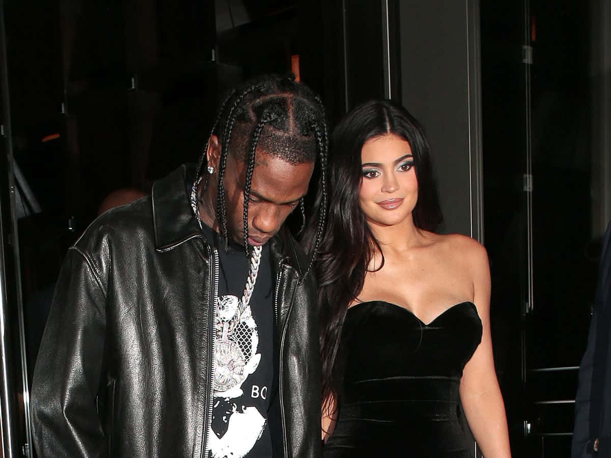 崔維斯·史考特 桌布 壁紙 — Travis Scott 和 Kylie Jenner 在夜晚穿著時尚的黑色服裝，搭配皮革和天鵝絨質地，一起散步。