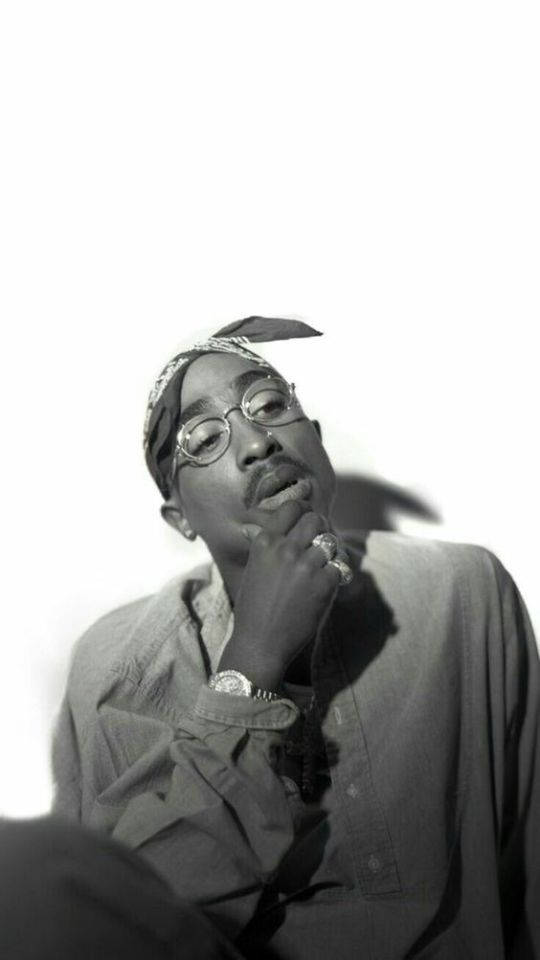 tupac 桌布 壁紙 — Tupac Shakur 的黑白肖像，戴著頭巾和眼鏡，手托下巴，背景為純白色。