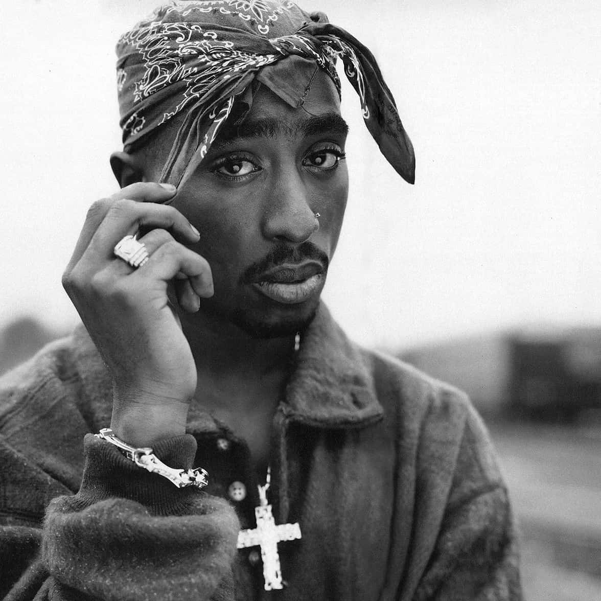 tupac 桌布 壁紙 — Tupac Shakur 的黑白肖像，戴著頭巾和十字架項鍊，手持電話貼在耳邊。