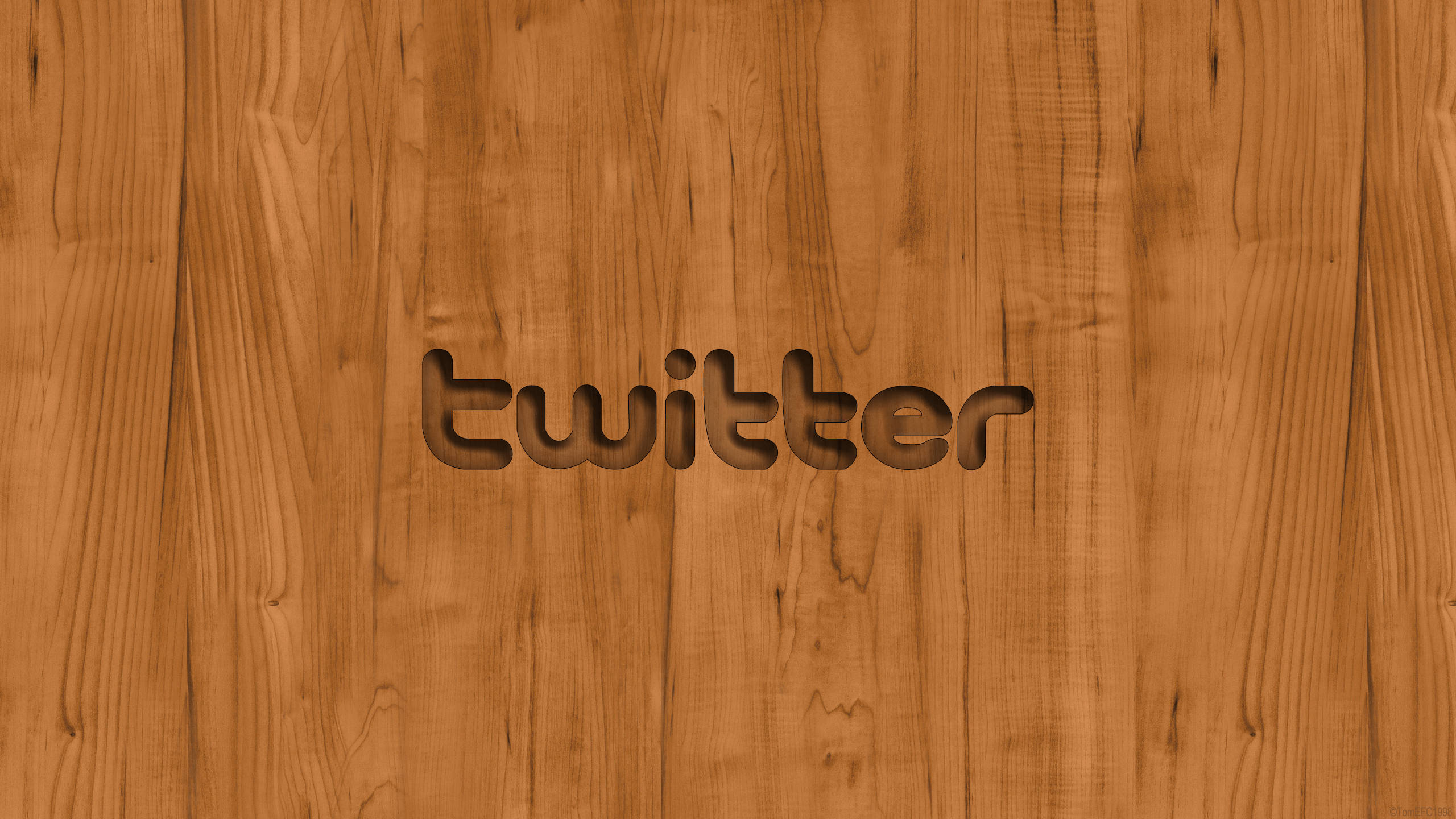 推特 桌布 壁紙 — 「twitter」這個字被雕刻在一個溫暖有質感的木質表面上，帶有天然木紋圖案。