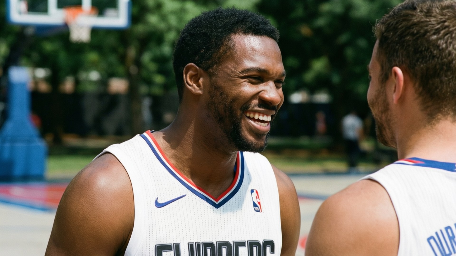 Laughing with Teammate 壁紙 — 兩名身穿快艇隊球衣的籃球運動員在明亮的陽光下於戶外球場一起大笑。