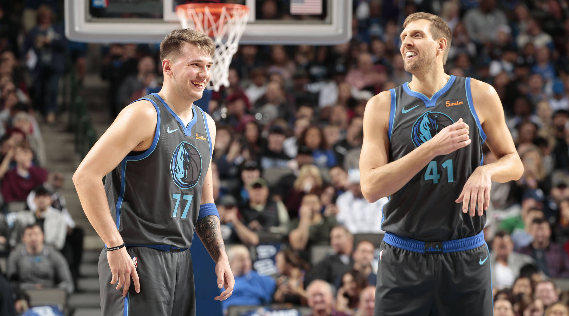 兩名籃球運動員在比賽中，在歡呼的觀眾面前大笑。 — NBA 壁紙