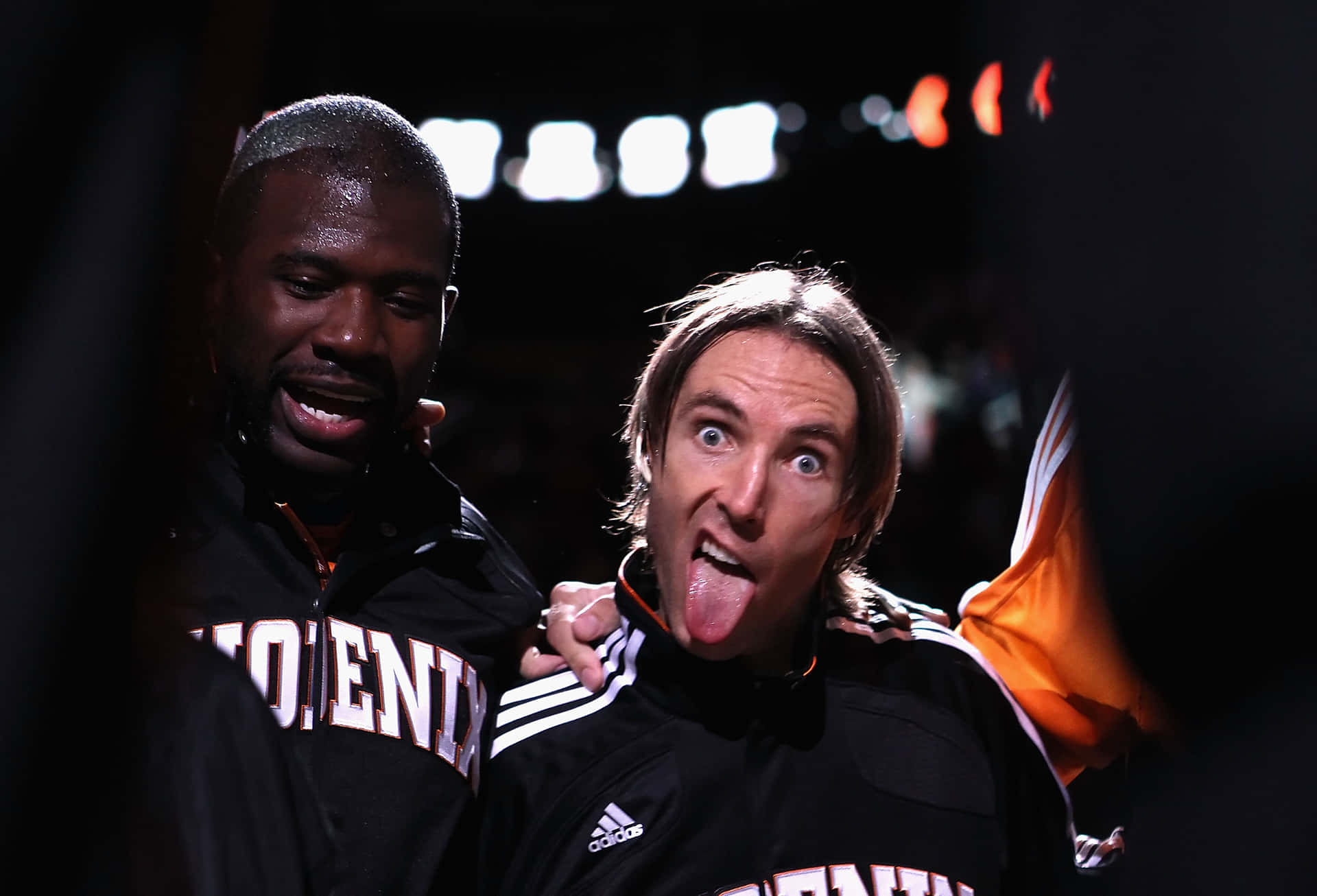 兩名籃球運動員在場館燈光下做鬼臉。 — NBA 壁紙
