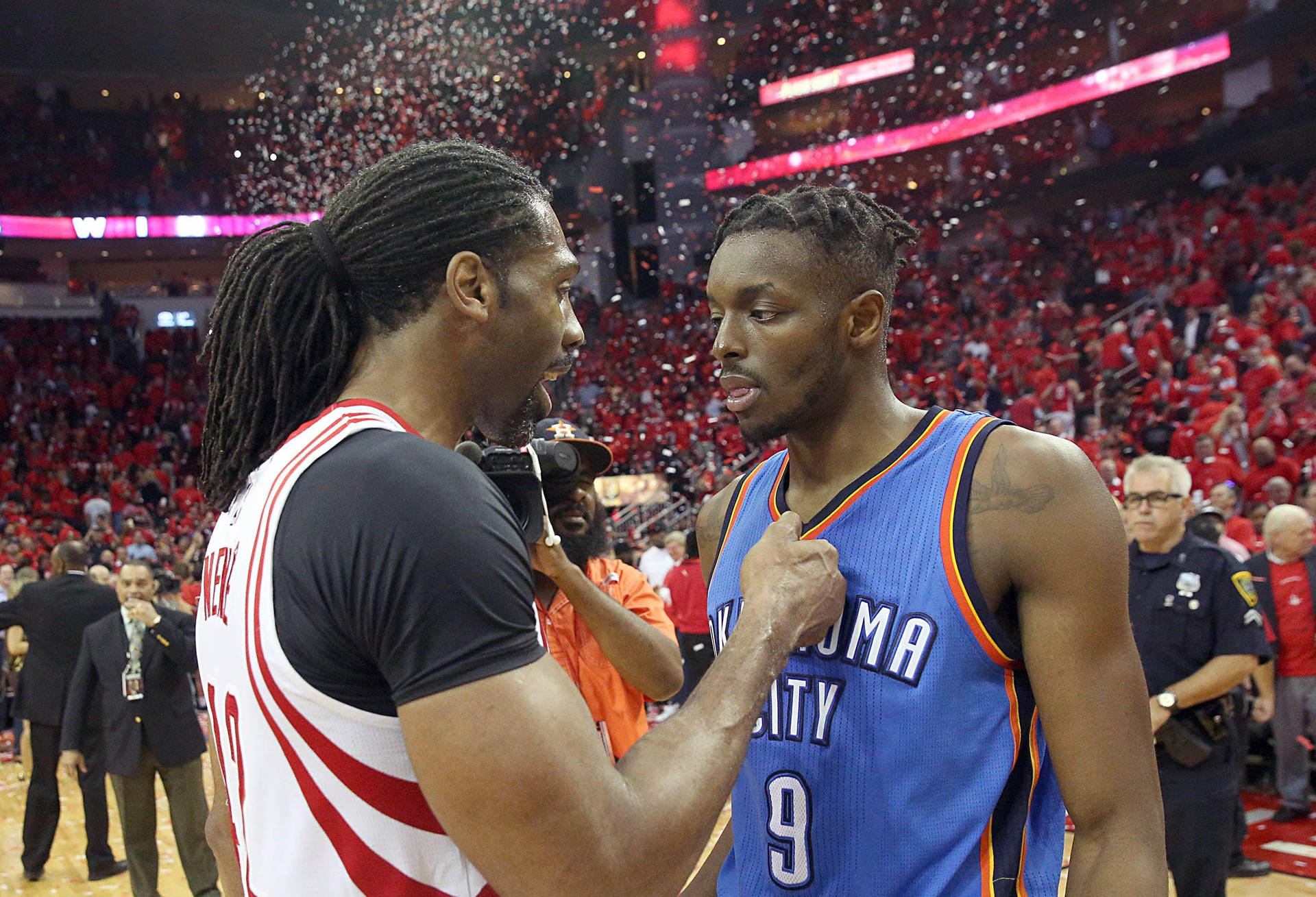 兩個籃球運動員在比賽中，在飄落的五彩紙屑中互相對峙。 — NBA 壁紙