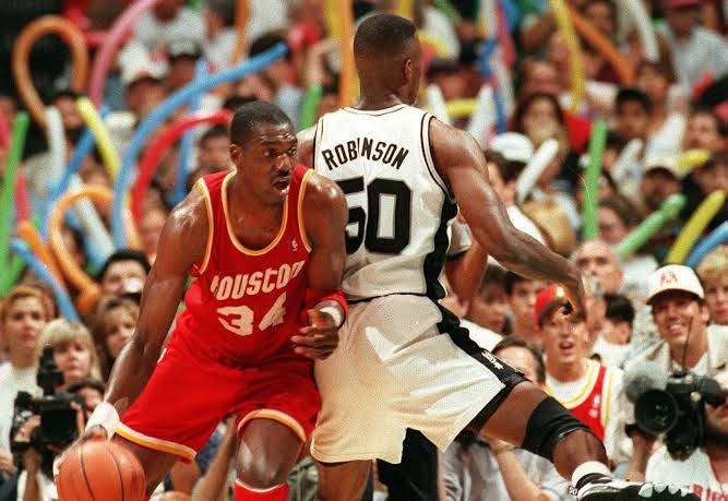 兩名籃球運動員在比賽中行動，球迷歡呼。 — NBA 壁紙