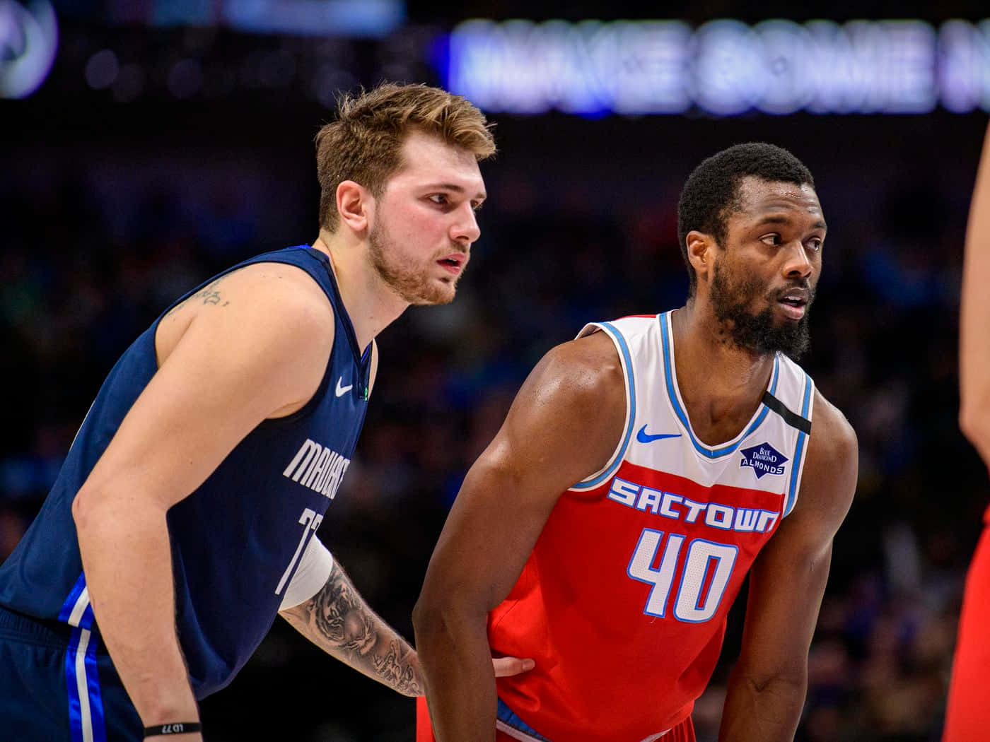 兩名職業籃球運動員在比賽中穿著球隊球衣行動。 — NBA 壁紙