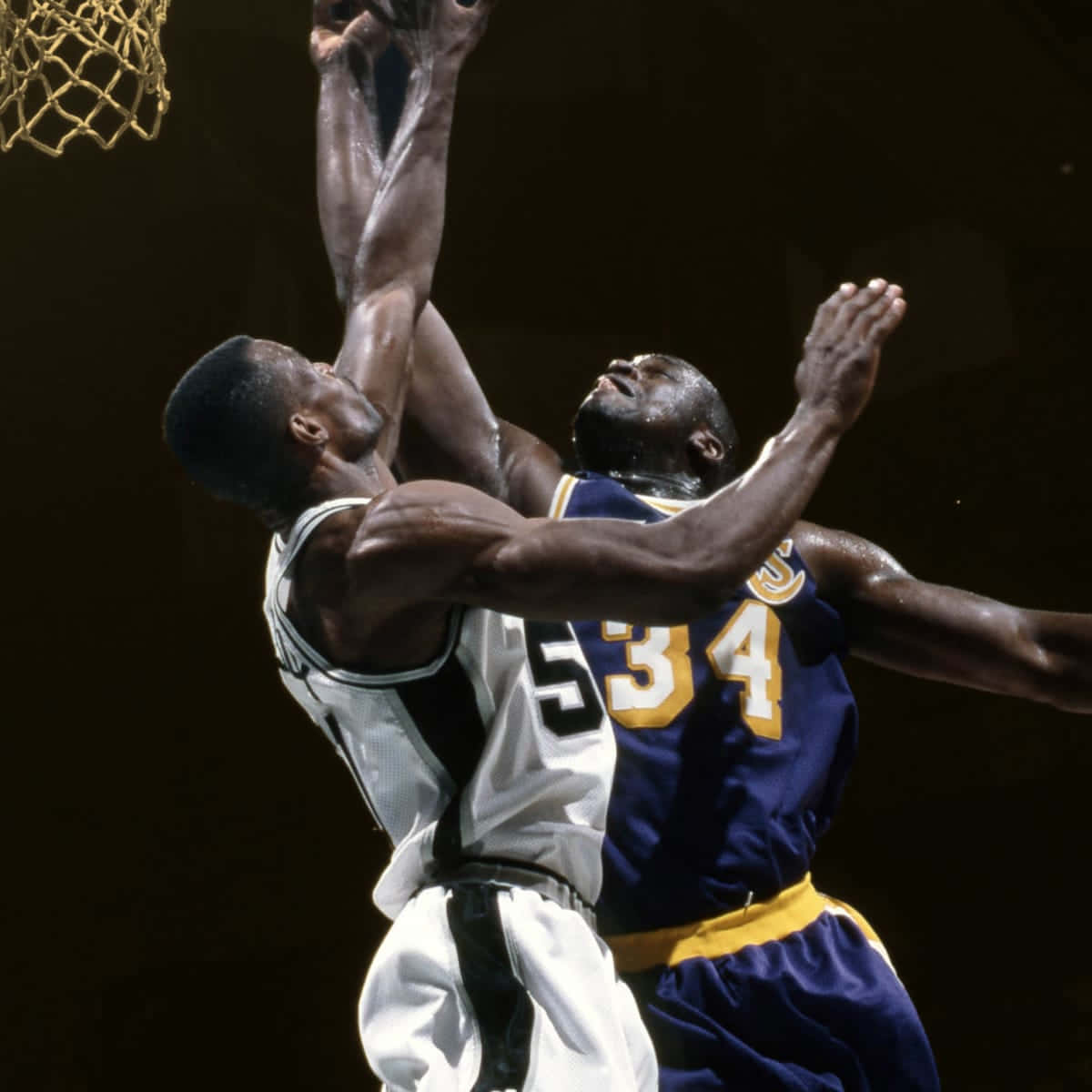 兩名籃球運動員在球場燈光下爭奪灌籃。 — NBA 壁紙