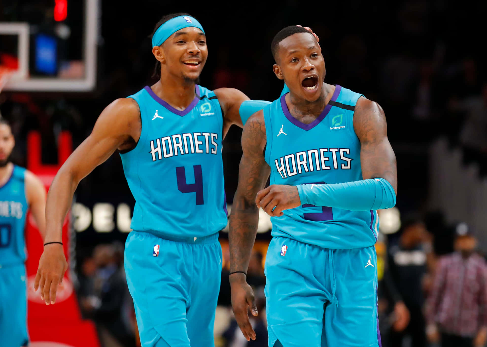 兩名身穿青綠色球衣的籃球運動員在比賽中慶祝。 — NBA 壁紙