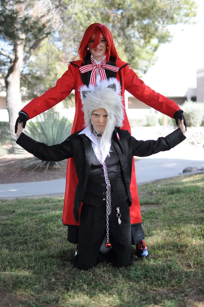 Black Butler Pluto 桌布 壁紙 — 兩位穿著精緻動漫服裝的角色扮演者在戶外草地上擺姿勢，背景有樹木和建築物。