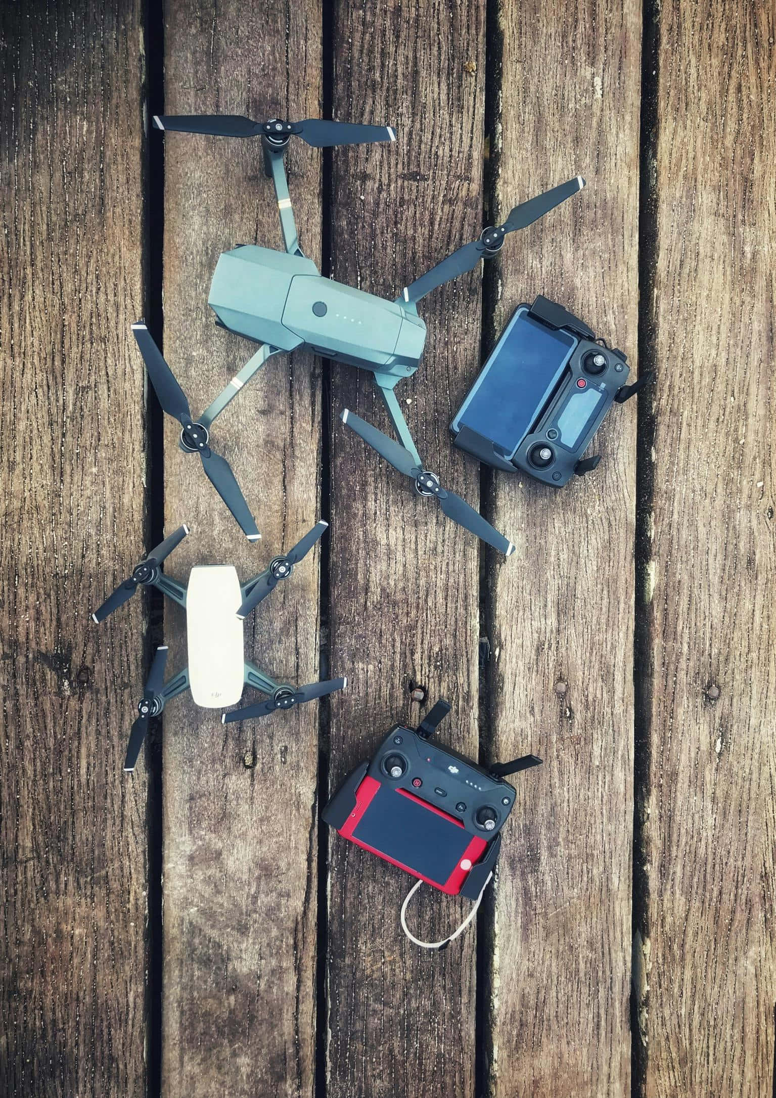 Drone Camera 桌布 壁紙 — 兩架無人機及其控制器放置在風化的木板上，俯視角度。