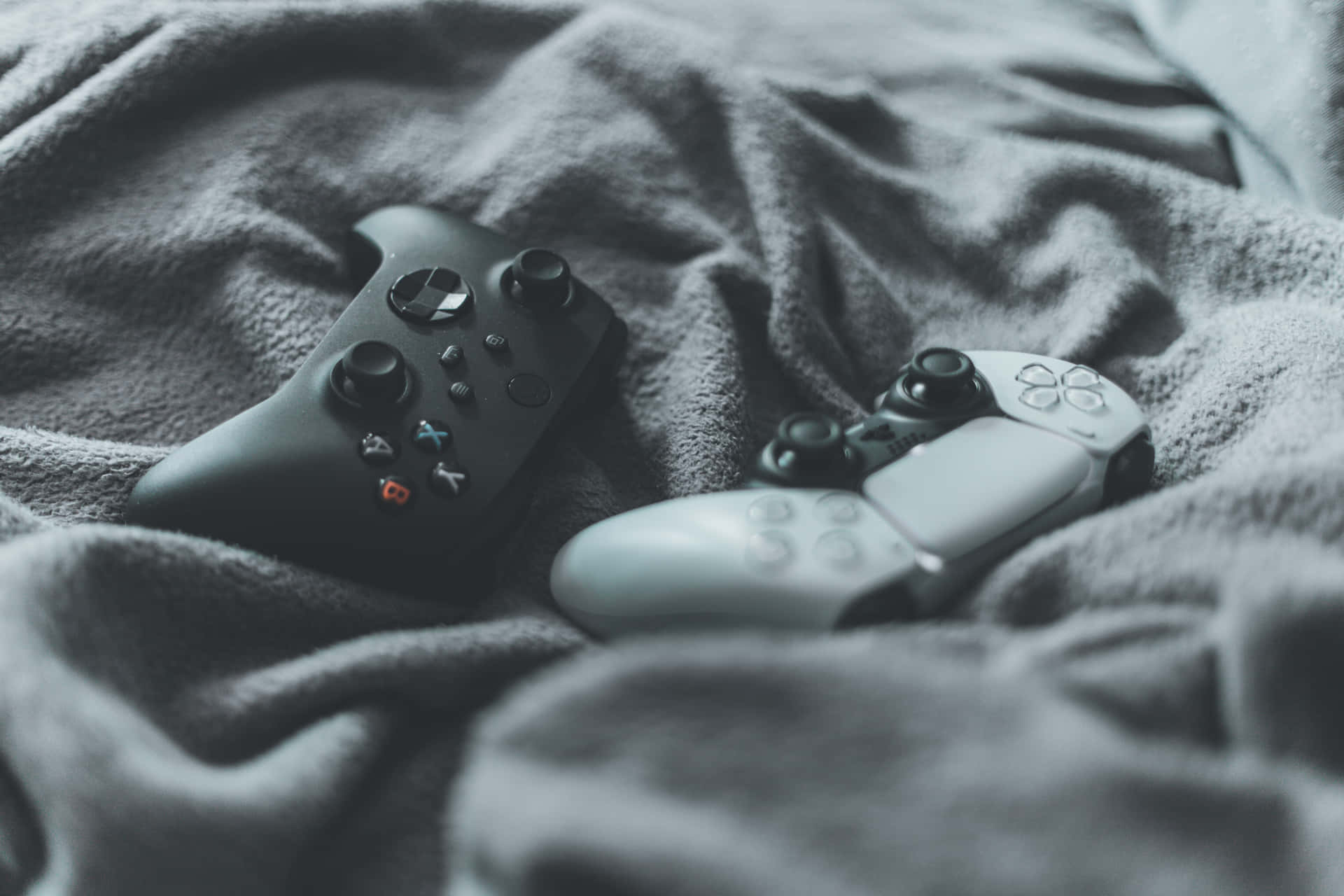 灰色毛毯上的兩個電子遊戲手把 — Ps4 壁紙