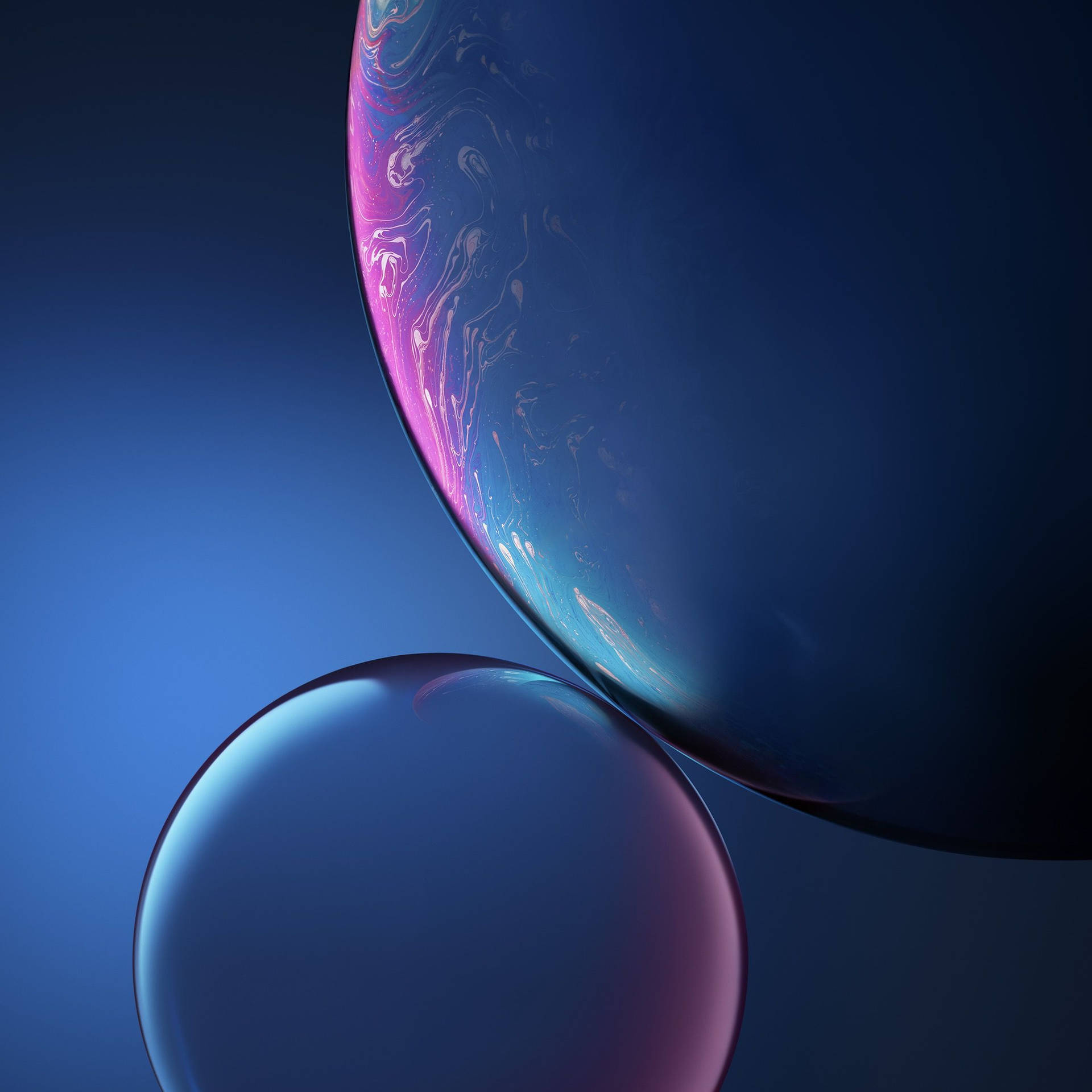 兩個漂浮的彩虹色肥皂泡，背景為藍色漸變。 — iPhone X 壁紙