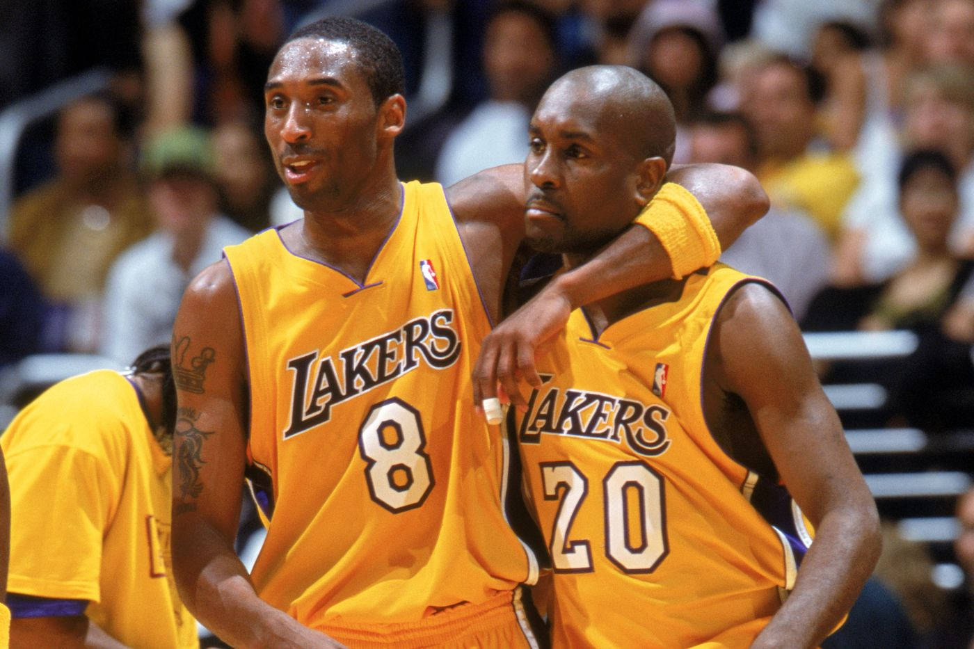 兩名身穿黃色球衣的湖人籃球運動員在比賽中擁抱。 — NBA 壁紙