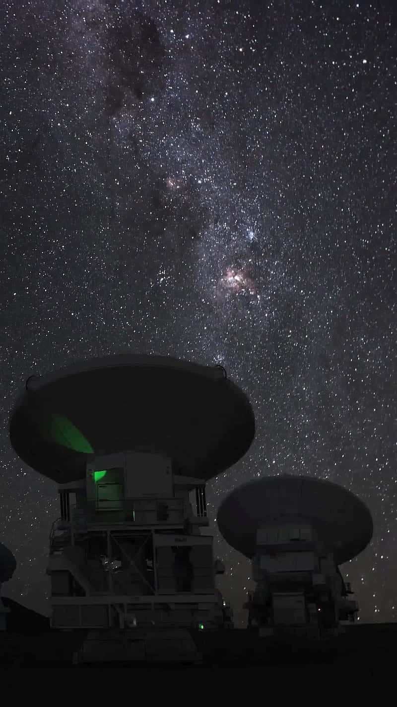  壁紙 — 兩座大型電波望遠鏡在壯麗的星空下呈現剪影，天空中充滿了銀河系發光的核心。