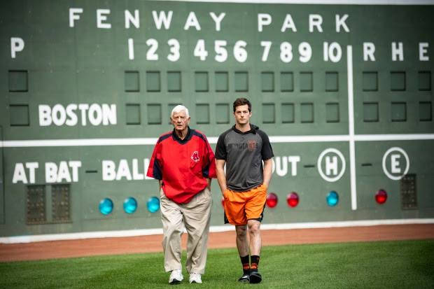 兩名男子在芬威球場記分板附近的棒球場上行走。 — MLB 壁紙