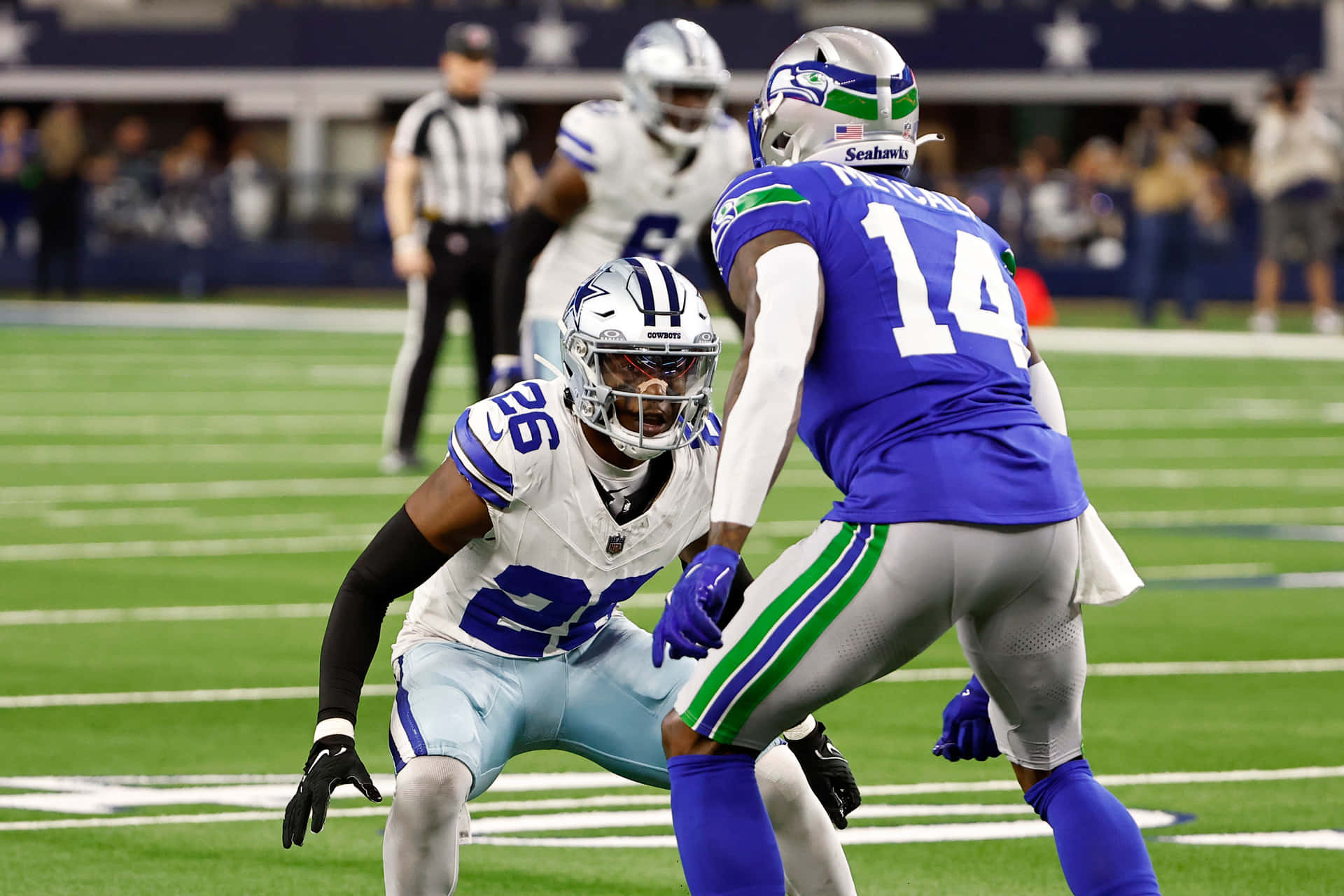  壁紙 — 兩名身穿藍白球衣的NFL球員在體育場燈光下，於充滿活力的綠色球場上激烈爭球。