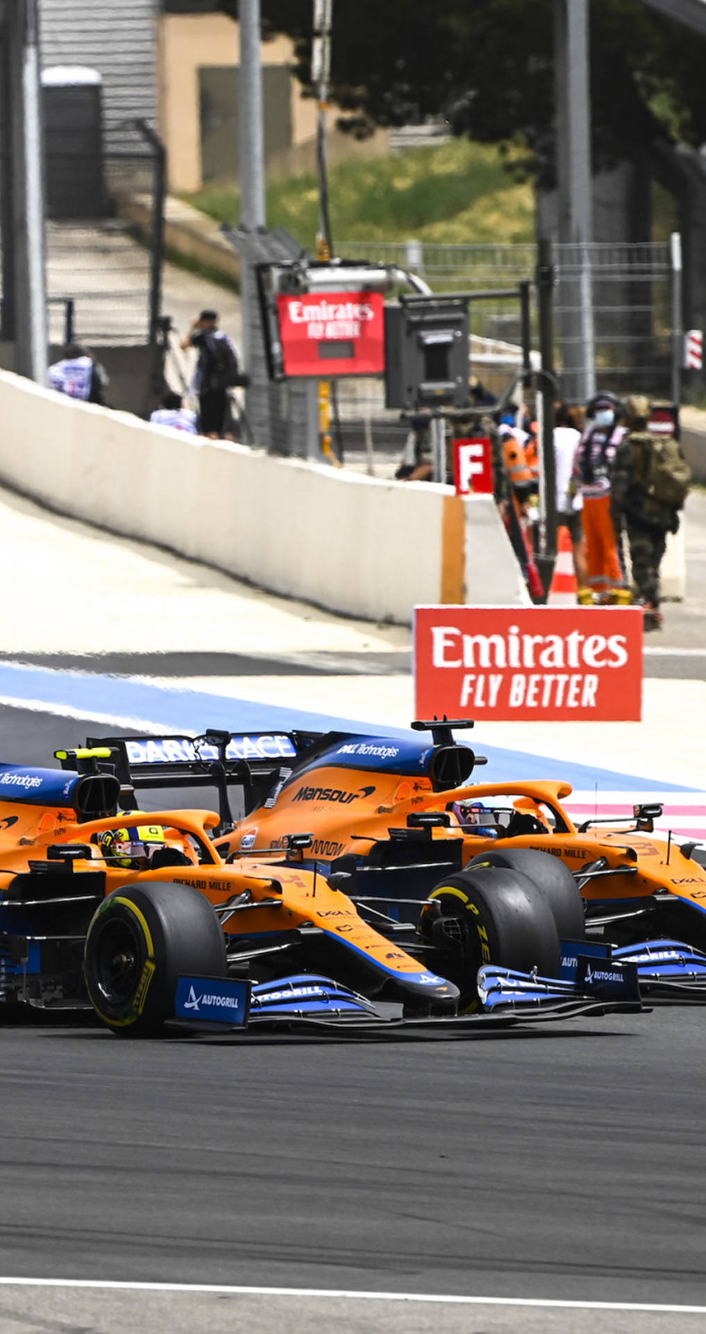 兩輛賽車在帶有阿聯酋航空廣告和安全護欄的賽道上飛馳。 — F1 壁紙