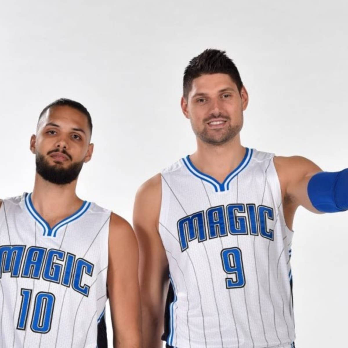 兩名奧蘭多魔術籃球運動員身穿白色和藍色球衣拍照。 — NBA 壁紙
