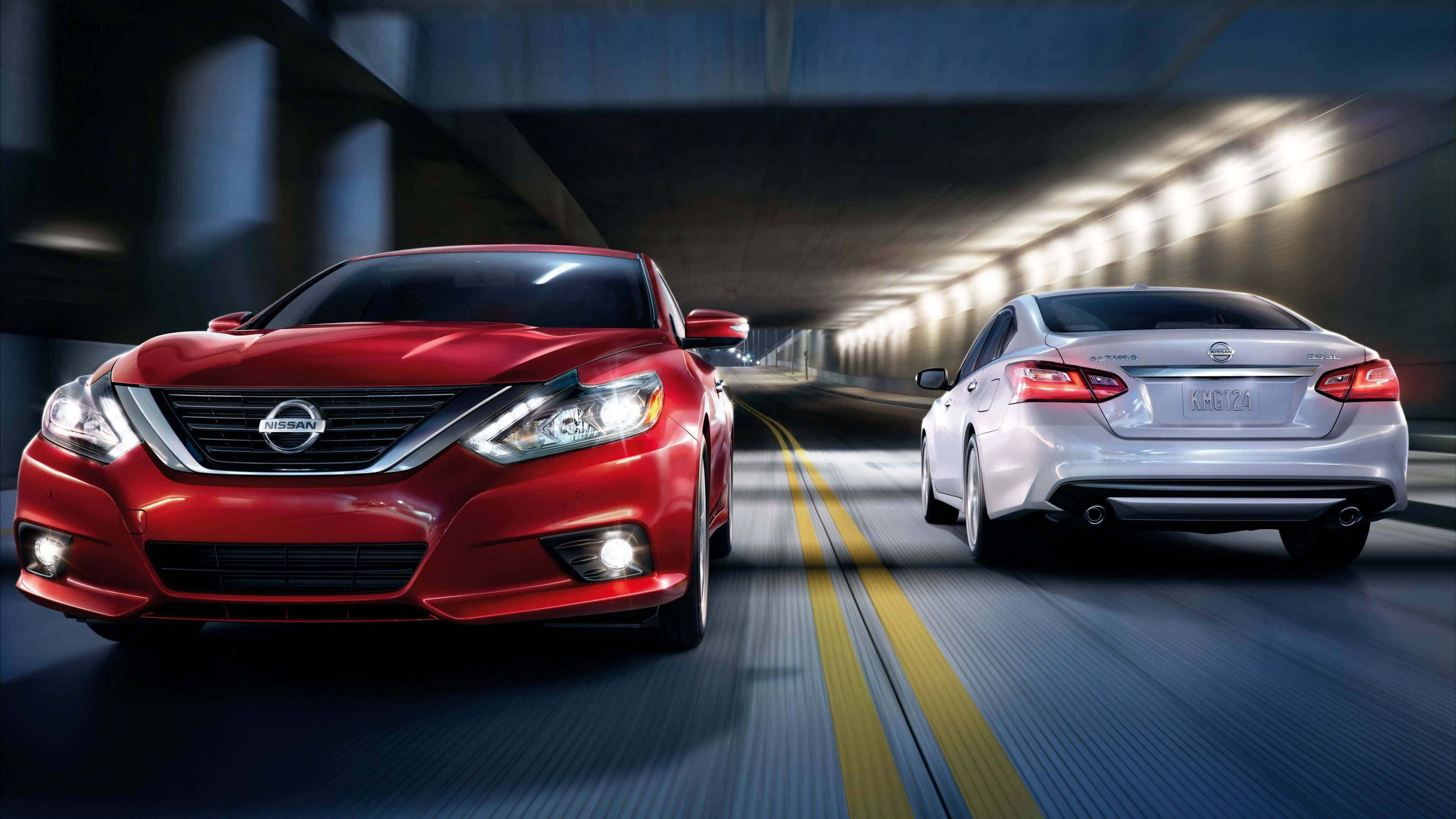 Nissan Altima 桌布 壁紙 — 兩輛時尚轎車，一輛紅色日產和一輛銀色轎車，在燈光昏暗的隧道中奔馳，帶有動態模糊條紋。