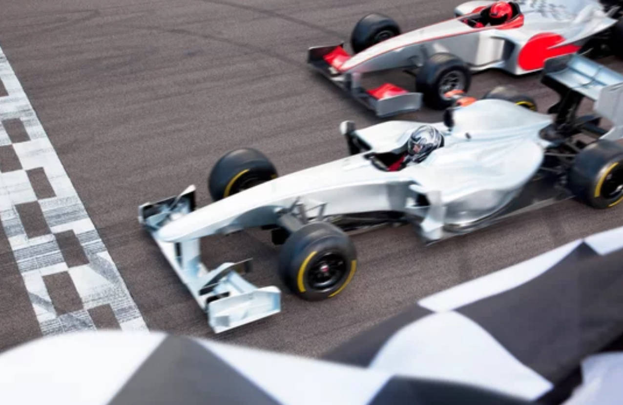 兩輛銀色賽車在賽道上越過方格旗終點線。 — F1 壁紙