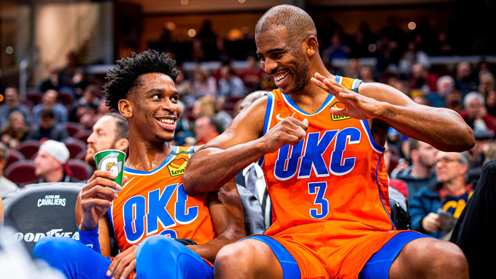 兩名身穿橙色球衣的籃球球員在比賽期間於板凳上慶祝。 — NBA 壁紙