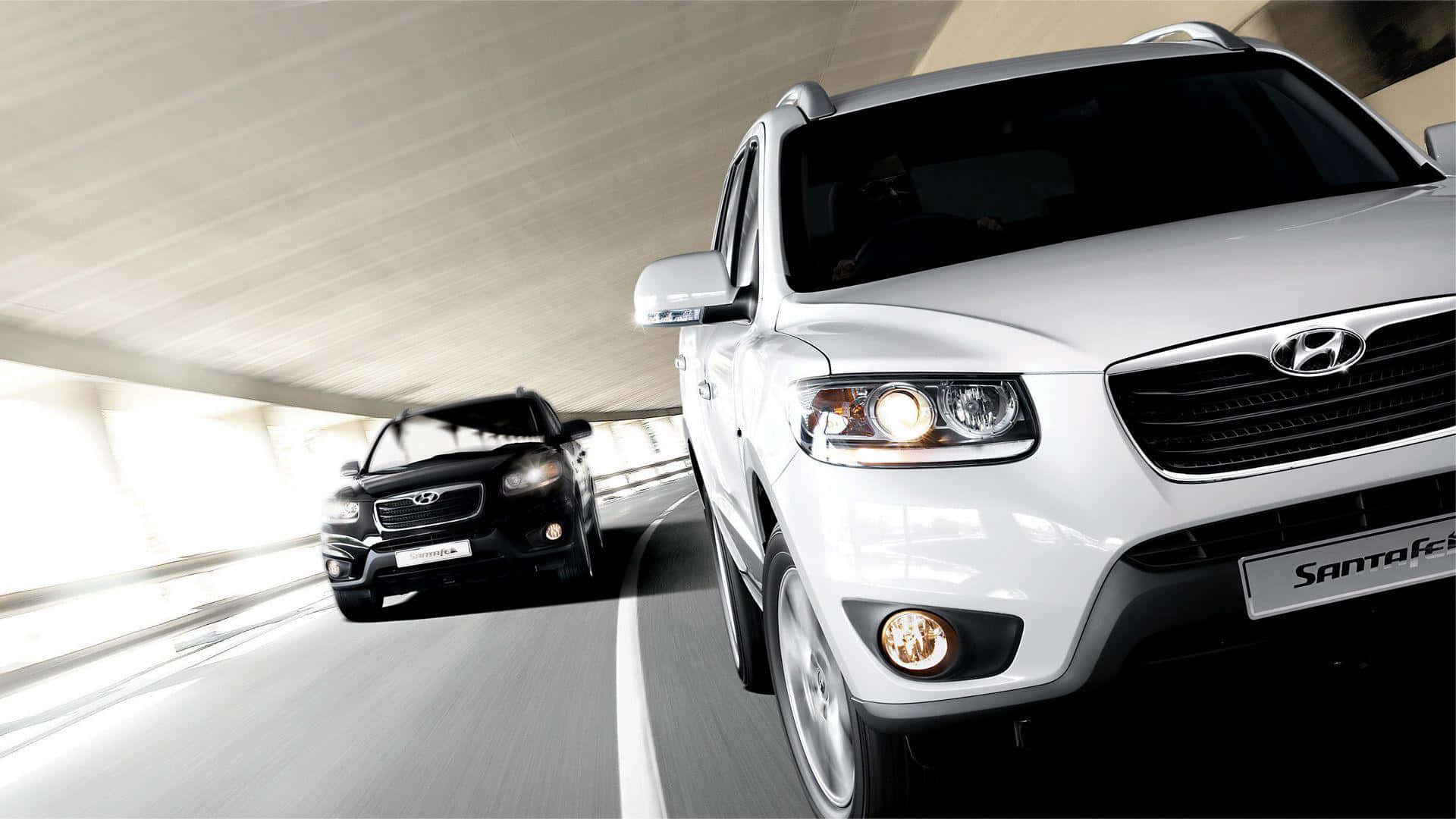 Hyundai Santa Fe 桌布 壁紙 — 兩輛SUV在陽光照射的隧道中疾馳，動態模糊強調速度和時尚設計。