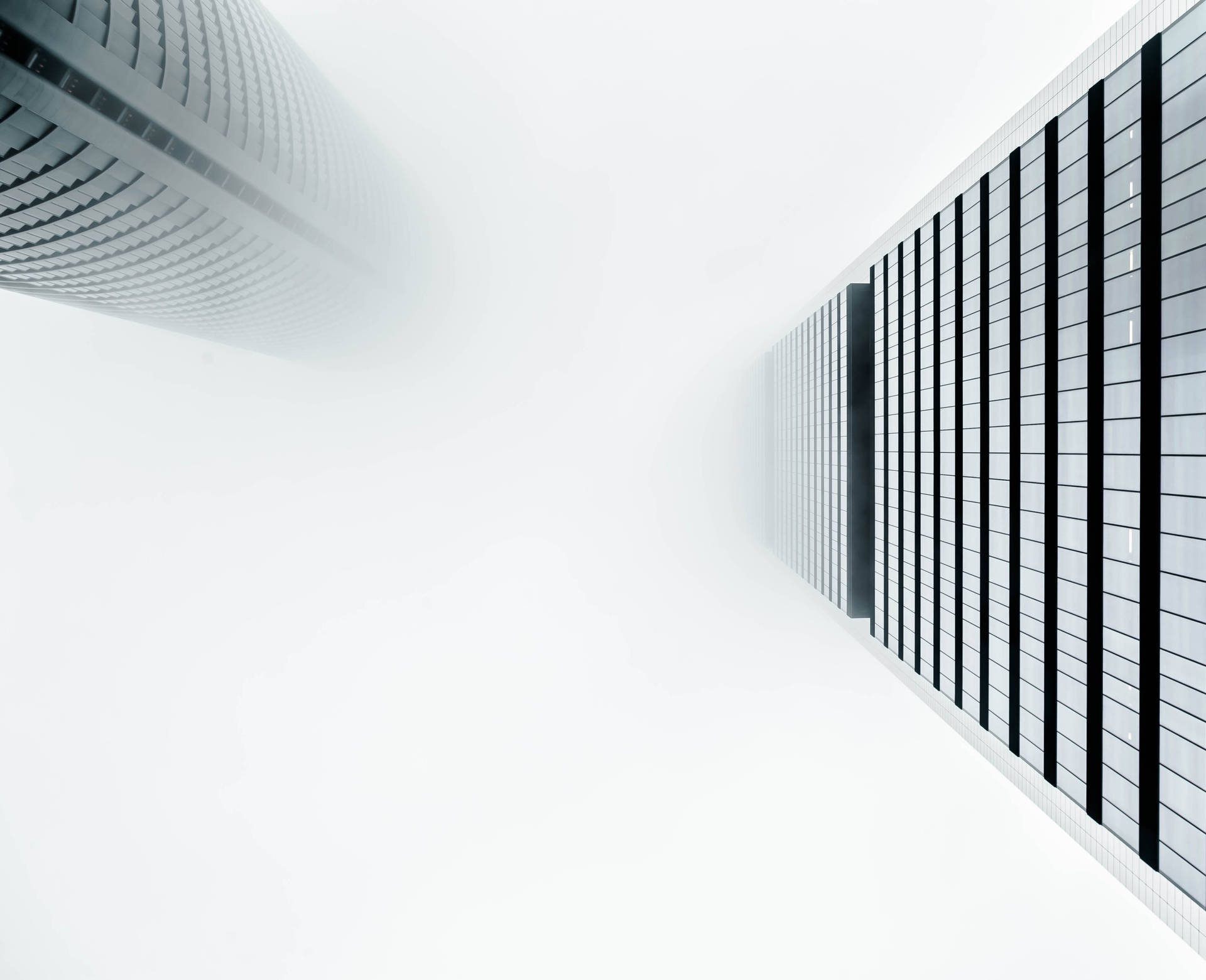 兩座現代摩天大樓在霧濛濛的城市環境中高聳入雲。 — 英雄聯盟 桌面 壁紙