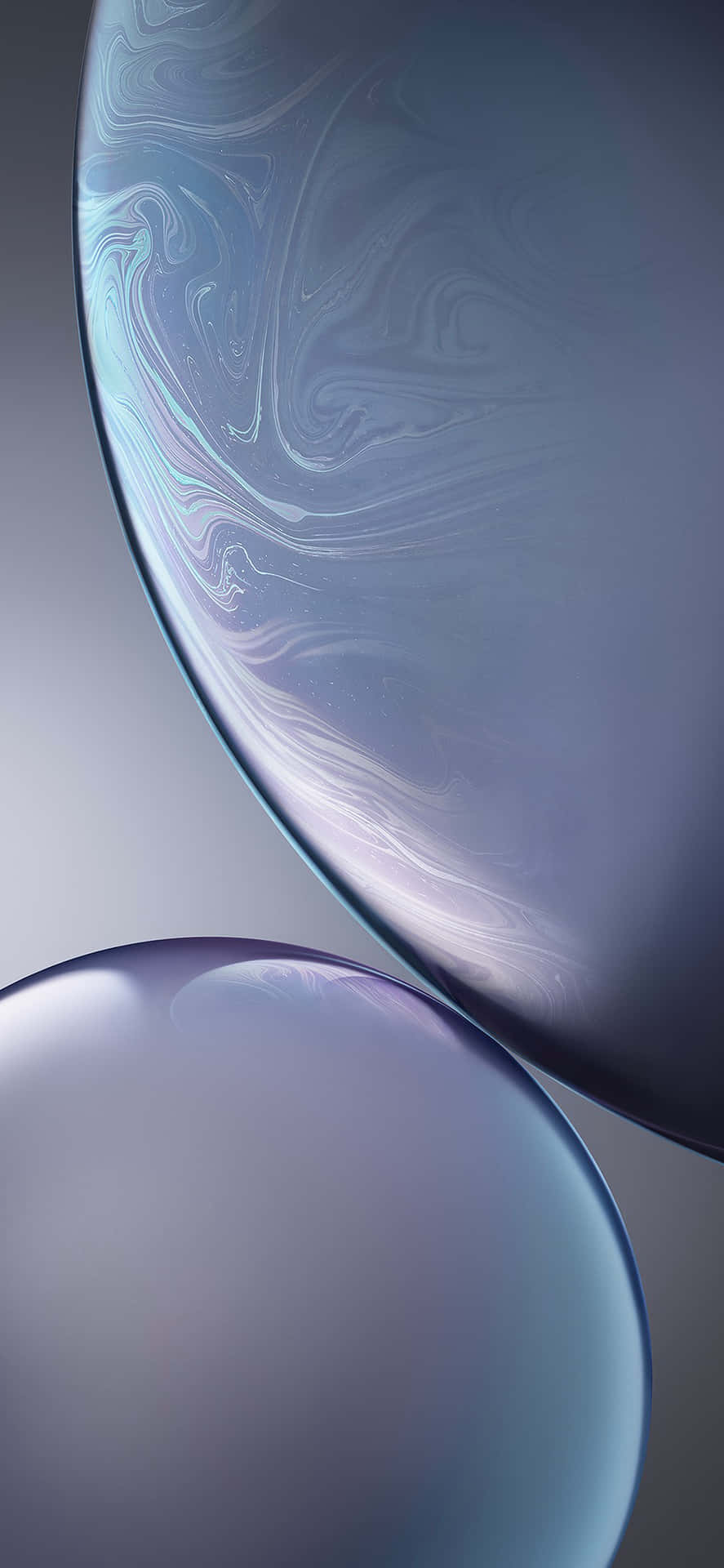 兩個漂浮的玻璃球體，帶有旋轉的藍色和紫色圖案。 — iPhone X 壁紙