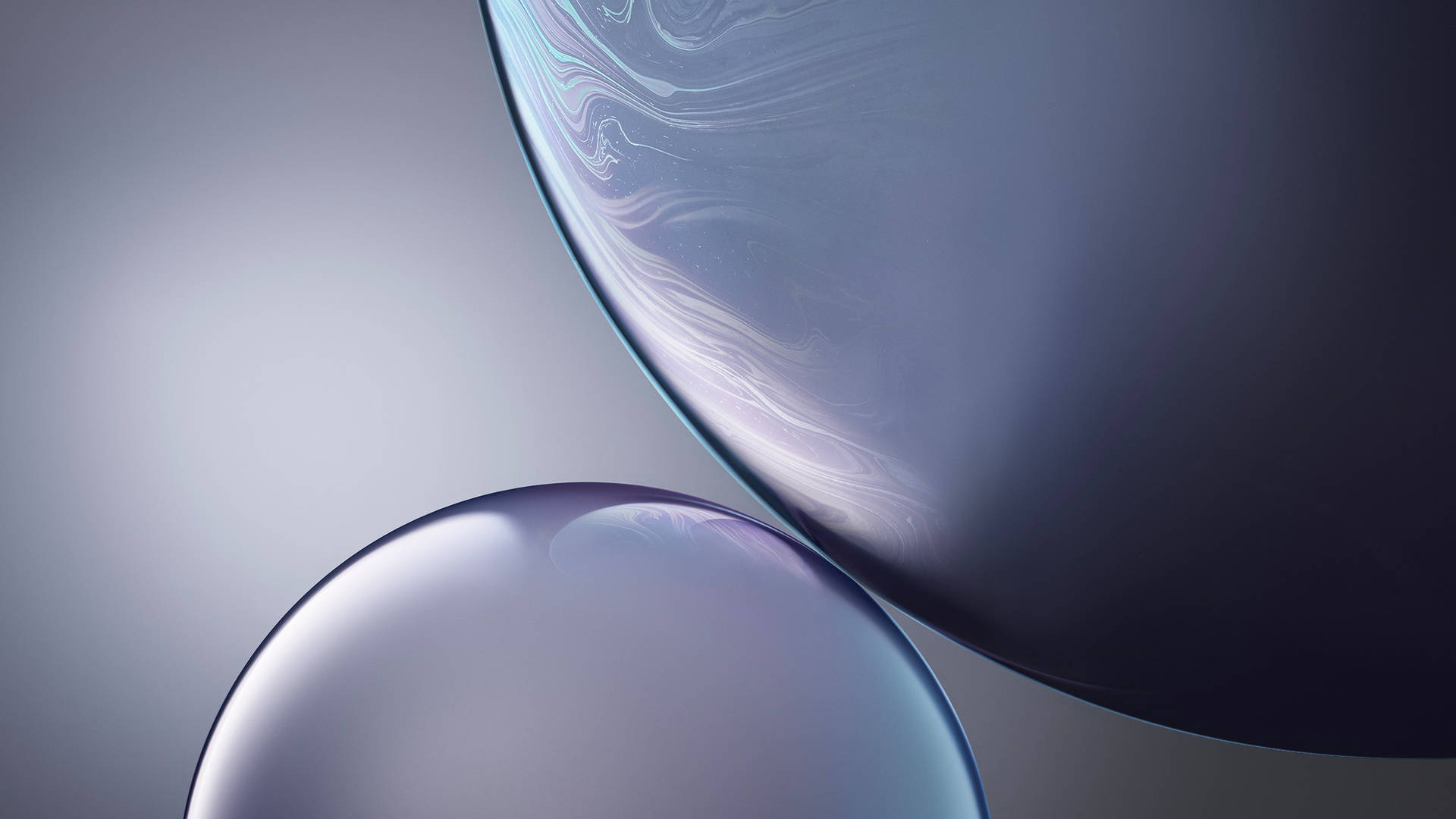 兩個帶有漩渦狀圖案的玻璃球體漂浮在太空中。 — iPhone 11 壁紙