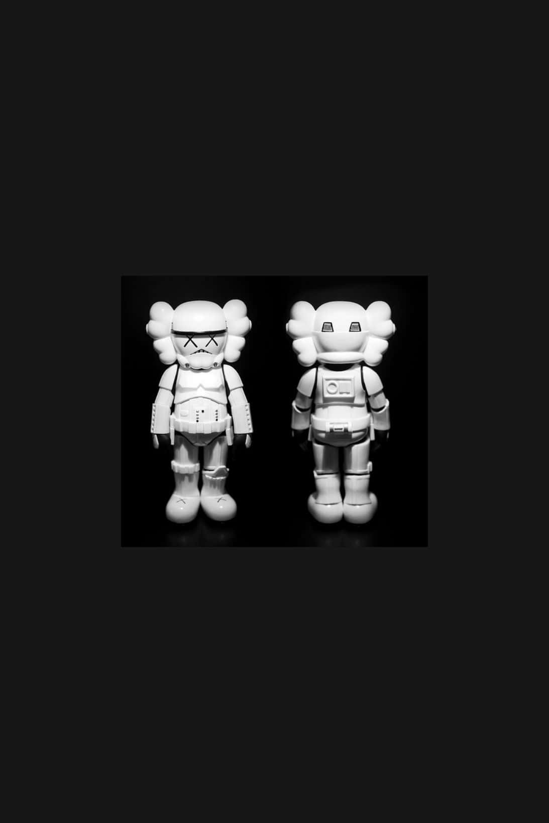 Kaws X Air Jordan 桌布 壁紙 — 兩個白色KAWS風暴兵人偶背對背站立在鮮明的黑色背景上，呈現高對比度的單色效果。