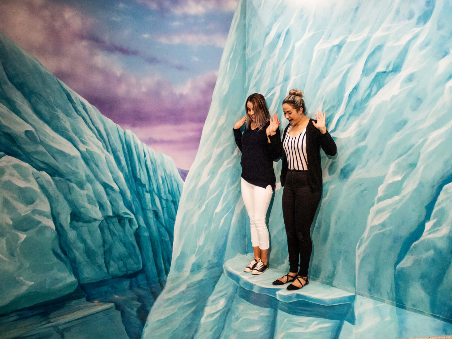 兩位女性在沉浸式藝術展覽中與3D彩繪冰峽谷牆互動。 — 3D 壁紙