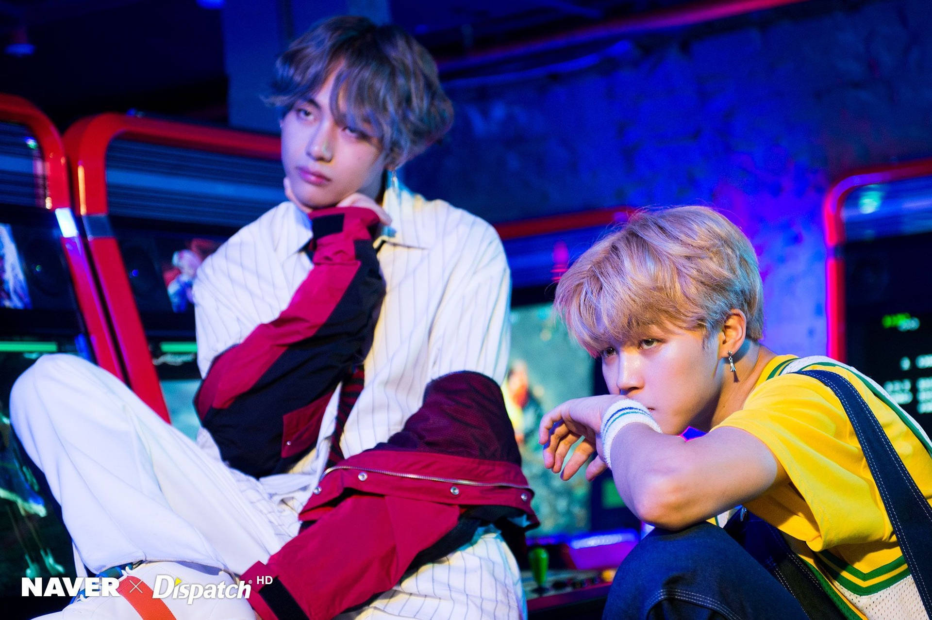 兩名身穿色彩繽紛服裝的年輕男子在霓虹遊戲機中心擺姿勢。 — Bts 壁紙