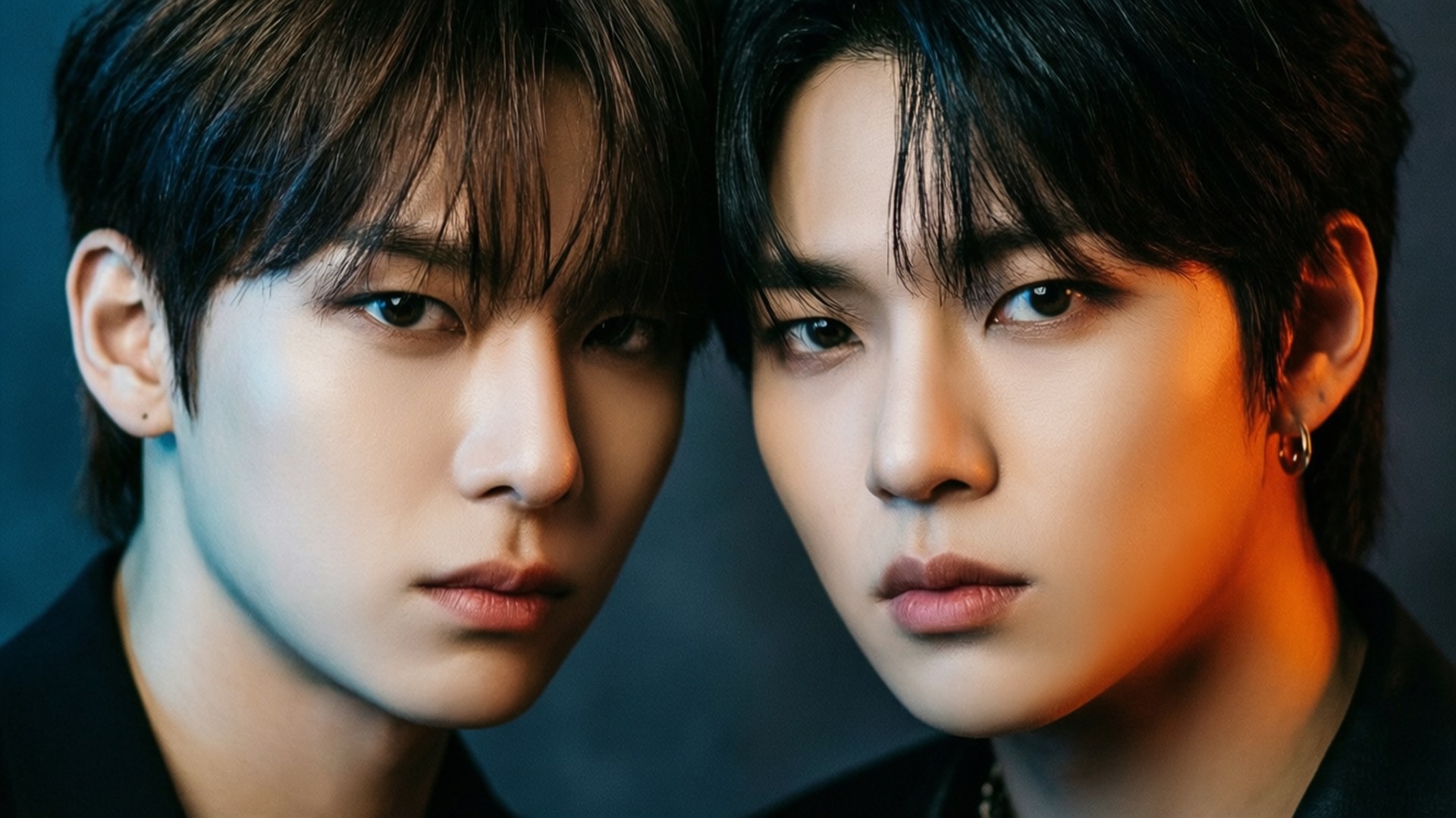 MONSTA X 桌布 壁紙 — 兩位年輕男子在深色背景下，於戲劇性的藍色和橙色燈光中，以強烈的目光直視前方。