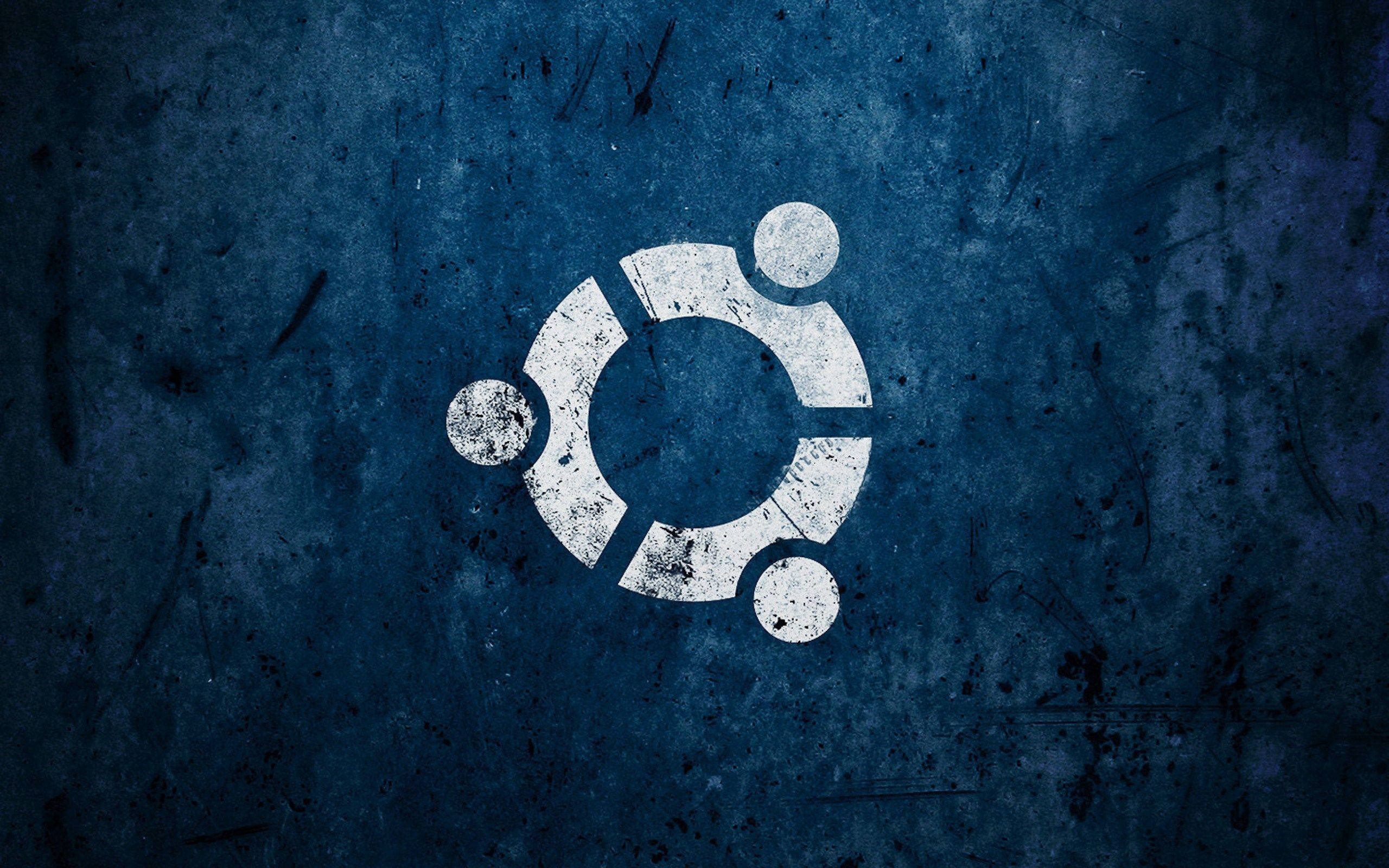 ubuntu 桌布 壁紙 — Ubuntu 標誌以風化白色塗在帶有刮痕和污垢的紋理深藍色牆壁上。